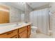 Cozy bathroom features a wooden vanity, floral wallpaper and shower-tub combo at 757 Hunt Club Trl, Port Orange, FL 32127