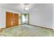 Carpeted bedroom with white walls, closet, ceiling fan, and window with green curtain trim at 757 Hunt Club Trl, Port Orange, FL 32127