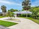 Attractive single-story home with brick exterior, well-manicured lawn, and mature palm trees at 757 Hunt Club Trl, Port Orange, FL 32127
