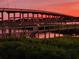Tranquil view of a bridge and waterfront at sunset, with warm light reflecting on the water's surface at 8 Richmond Dr, New Smyrna Beach, FL 32169