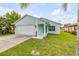 Charming one-story home featuring a well-manicured lawn and an attached two-car garage at 805 Spruce St, New Smyrna Beach, FL 32168