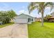 Charming single Gathering home featuring an attached two car garage, a well maintained lawn and lush tropical landscaping at 805 Spruce St, New Smyrna Beach, FL 32168
