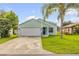Charming single Gathering home featuring an attached two car garage, a well maintained lawn and lush tropical landscaping at 805 Spruce St, New Smyrna Beach, FL 32168