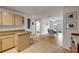 Open kitchen with tan cabinets, tile backsplash, and views of the dining area and backyard at 805 Spruce St, New Smyrna Beach, FL 32168