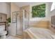 A bright bathroom featuring a glass shower enclosure, soaking tub, and a decorative green wall at 850 Wingate Trl, Port Orange, FL 32128