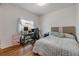 A cozy bedroom featuring wood floors, a workstation, and a comfortable bed with decorative pillows at 850 Wingate Trl, Port Orange, FL 32128