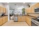 Spacious kitchen featuring wooden cabinetry, tile flooring, and modern stainless steel appliances at 850 Wingate Trl, Port Orange, FL 32128