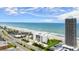 Stunning aerial view of the beach with the Aliki Atrium and adjacent high rise condominium at 901 S Atlantic Ave # 202, Ormond Beach, FL 32176