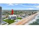 Drone view of the building with beach access, a pool and tennis courts at 901 S Atlantic Ave # 202, Ormond Beach, FL 32176