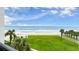 Expansive backyard with palm trees, grassy area, and a scenic view of the ocean and beach at 901 S Atlantic Ave # 202, Ormond Beach, FL 32176