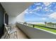 Relaxing balcony with chairs and tables, overlooking a grassy yard, beach, and ocean views at 901 S Atlantic Ave # 202, Ormond Beach, FL 32176