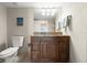 Bathroom featuring a granite countertop, dark wood vanity and a large framed mirror at 901 S Atlantic Ave # 202, Ormond Beach, FL 32176