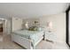 Spacious bedroom featuring ocean view, rug, lamps, and ensuite bathroom at 901 S Atlantic Ave # 202, Ormond Beach, FL 32176