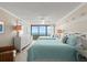 Bright bedroom with two beds, a dresser, and ocean views from the sliding glass doors to the balcony at 901 S Atlantic Ave # 202, Ormond Beach, FL 32176
