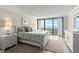 Comfortable bedroom with a plush rug, sliding glass door and view of the ocean at 901 S Atlantic Ave # 202, Ormond Beach, FL 32176
