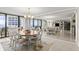 Bright dining room with chandelier, seating for six, and sliding glass doors to a large balcony overlooking the ocean at 901 S Atlantic Ave # 202, Ormond Beach, FL 32176
