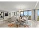 Open-concept living and dining area features a chandelier, balcony access, and ample natural light with ocean views at 901 S Atlantic Ave # 202, Ormond Beach, FL 32176