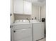Functional laundry room with a white washer and dryer, along with built-in cabinets for storage at 901 S Atlantic Ave # 202, Ormond Beach, FL 32176