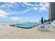 Relaxing in-ground pool with patio seating and umbrellas for a calming day at the beach at 901 S Atlantic Ave # 202, Ormond Beach, FL 32176