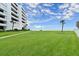 Expansive green lawn offers a peaceful view of the ocean and the Aliki Atrium building at 901 S Atlantic Ave # 202, Ormond Beach, FL 32176