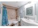 Well-lit bathroom featuring a stylish vanity, tiled shower with curtain, toilet, and tasteful decor at 1 Oceans West Blvd # 1B5, Daytona Beach, FL 32118