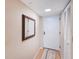 Clean hallway with a decorative mirror and closet, featuring wood-look floors at 1 Oceans West Blvd # 1B5, Daytona Beach, FL 32118