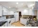 Bright kitchen features granite countertops, white appliances, and wood-look floors at 1 Oceans West Blvd # 1B5, Daytona Beach, FL 32118