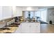 A well-lit kitchen featuring granite countertops, white cabinets, and a convenient pass-through to the living area at 1 Oceans West Blvd # 1B5, Daytona Beach, FL 32118