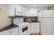 Compact kitchen features white appliances, ample cabinet space, and sleek black countertops at 1 Oceans West Blvd # 1B5, Daytona Beach, FL 32118