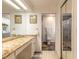 Bathroom featuring granite counters, ample mirrors, and an open door into a shower and laundry room at 1237 Charter Oaks Cir, Daytona Beach, FL 32117