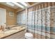 Cozy bathroom showcasing a granite countertop, mirrored wall, and decorative shower curtain at 1237 Charter Oaks Cir, Daytona Beach, FL 32117