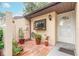 Cozy courtyard entrance featuring a brick-paved area and lush potted plants at 1237 Charter Oaks Cir, Daytona Beach, FL 32117