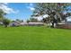 Large backyard with lush green grass and surrounding trees offers a serene retreat at 132 E Turgot Ave, Edgewater, FL 32132
