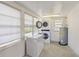 Well-lit laundry room with washer, dryer, chest freezer, and water heater at 132 E Turgot Ave, Edgewater, FL 32132