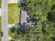 Aerial view of a home nestled among mature trees with a spacious yard and long driveway at 1421 Pine Tree Dr, Edgewater, FL 32132