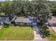 An overhead shot showcasing the property with its green lawn, mature trees, and proximity to neighboring homes at 1421 Pine Tree Dr, Edgewater, FL 32132