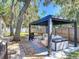Spacious backyard featuring a stylish pergola with lounge seating and outdoor grilling area at 1421 Pine Tree Dr, Edgewater, FL 32132