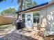 Backyard view with brick patio, grill, and mature trees offering plenty of shade at 1421 Pine Tree Dr, Edgewater, FL 32132