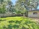 Expansive backyard with mature trees, a well-maintained lawn, and a relaxing pergola area at 1421 Pine Tree Dr, Edgewater, FL 32132
