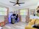 Bright bedroom with a ceiling fan, large windows, and a yellow couch, perfect for a home office at 1421 Pine Tree Dr, Edgewater, FL 32132