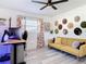 Bright bedroom with a ceiling fan, large windows, and a yellow couch, perfect for a home office at 1421 Pine Tree Dr, Edgewater, FL 32132