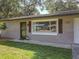 Close-up of the front of a charming home with a brick facade and window shutters at 1421 Pine Tree Dr, Edgewater, FL 32132