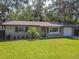 Eye-level shot of a meticulously landscaped property with manicured lawns and trees at 1421 Pine Tree Dr, Edgewater, FL 32132