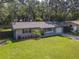 Beautifully landscaped home with fresh green grass, mature trees, and a charming front exterior at 1421 Pine Tree Dr, Edgewater, FL 32132