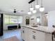 Bright kitchen island with granite countertop and seating, with a window view of the front yard at 1421 Pine Tree Dr, Edgewater, FL 32132