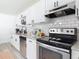 Close up of kitchen features: stainless steel appliances, granite countertops, and subway tile backsplash at 1421 Pine Tree Dr, Edgewater, FL 32132