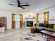 Bright living room features fireplace, large windows, modern lighting, and comfortable green sectional at 1421 Pine Tree Dr, Edgewater, FL 32132