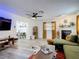 Living room with fireplace, green sofa, and views into kitchen and dining area in an open floorplan at 1421 Pine Tree Dr, Edgewater, FL 32132