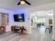 Open concept living room flows into kitchen and dining area, with modern media center and decor at 1421 Pine Tree Dr, Edgewater, FL 32132