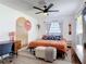 Comfortable main bedroom featuring a ceiling fan, hardwood floors, and plentiful light from a large window at 1421 Pine Tree Dr, Edgewater, FL 32132
